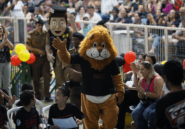 Alunos e mascotes PM Amigo Legal e Dare na cerimônia PROERD no Ginásio Poliesportivo, Extrema, 2025